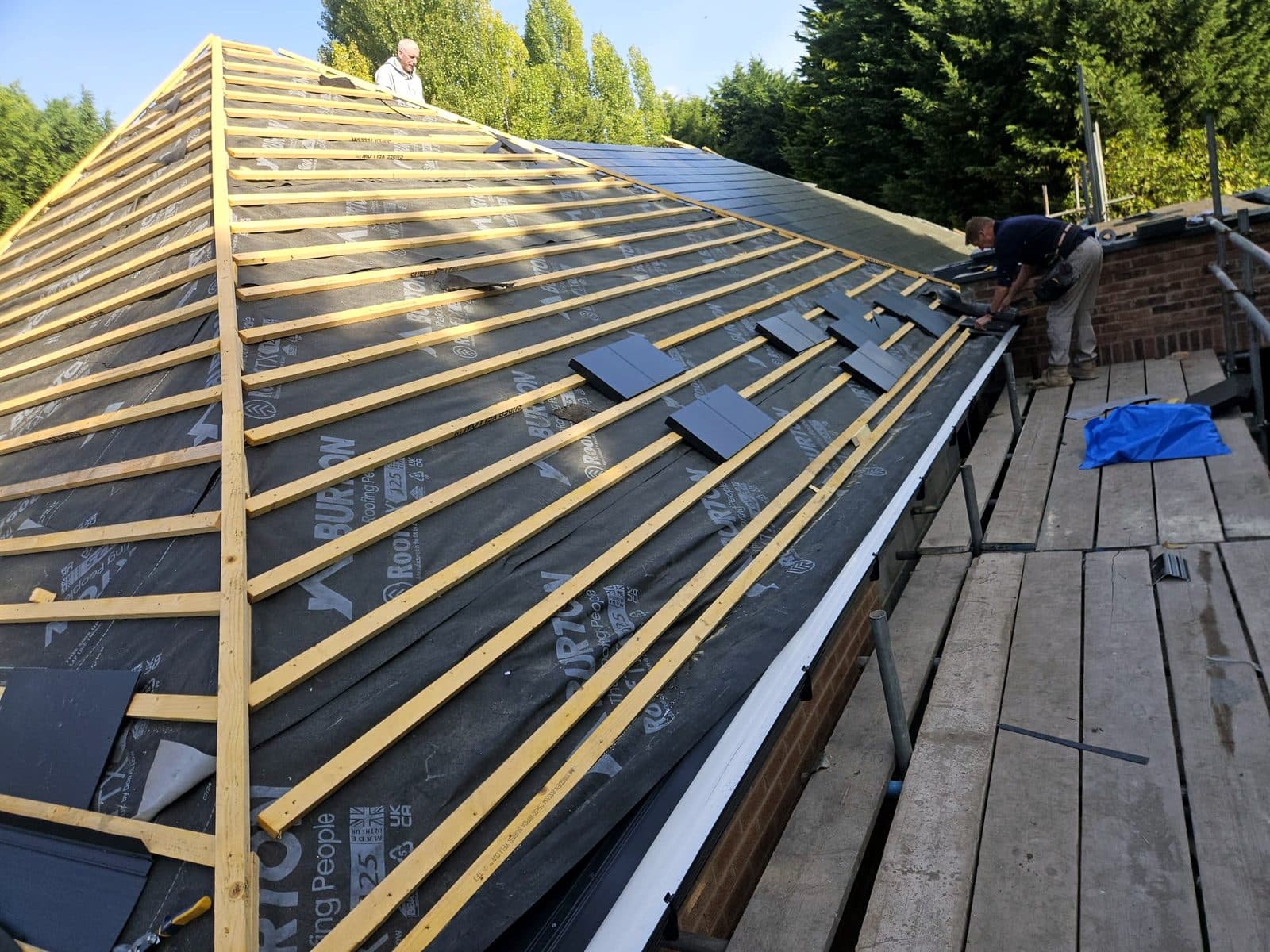 Slating over new membrane and battens, working from the scaffold