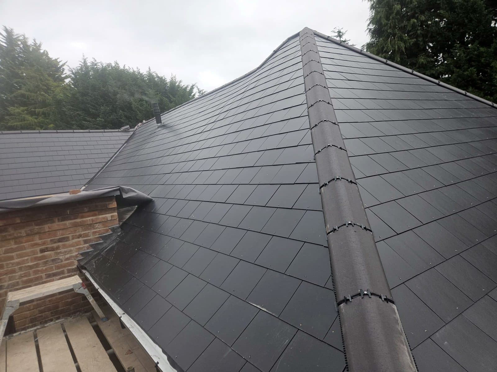 The finished slate roof with a new hip and ridge, flashed in lead where it meets the brickwork
