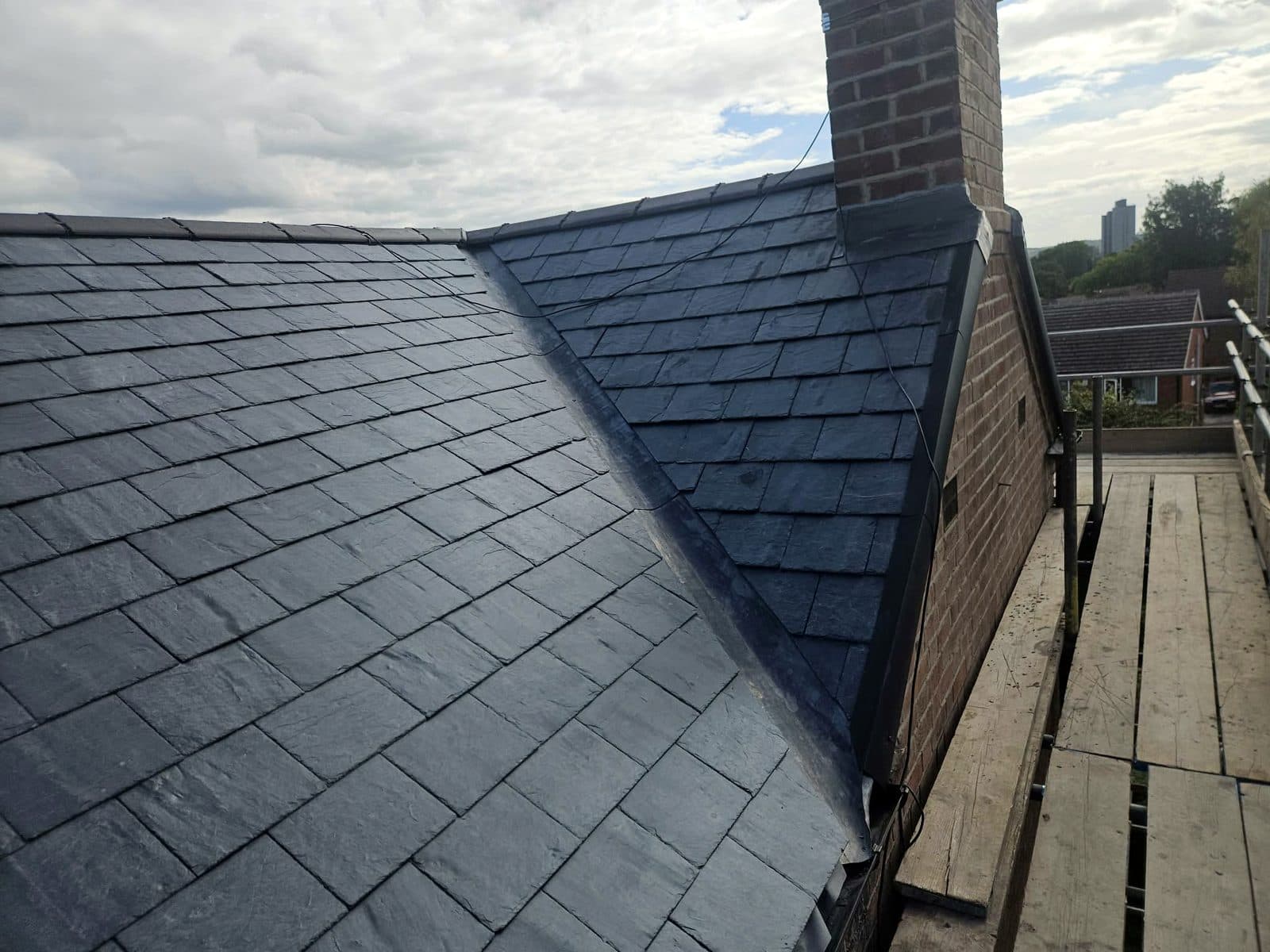 A new lead valley where two slate slopes meet, with the chimney flashed in lead