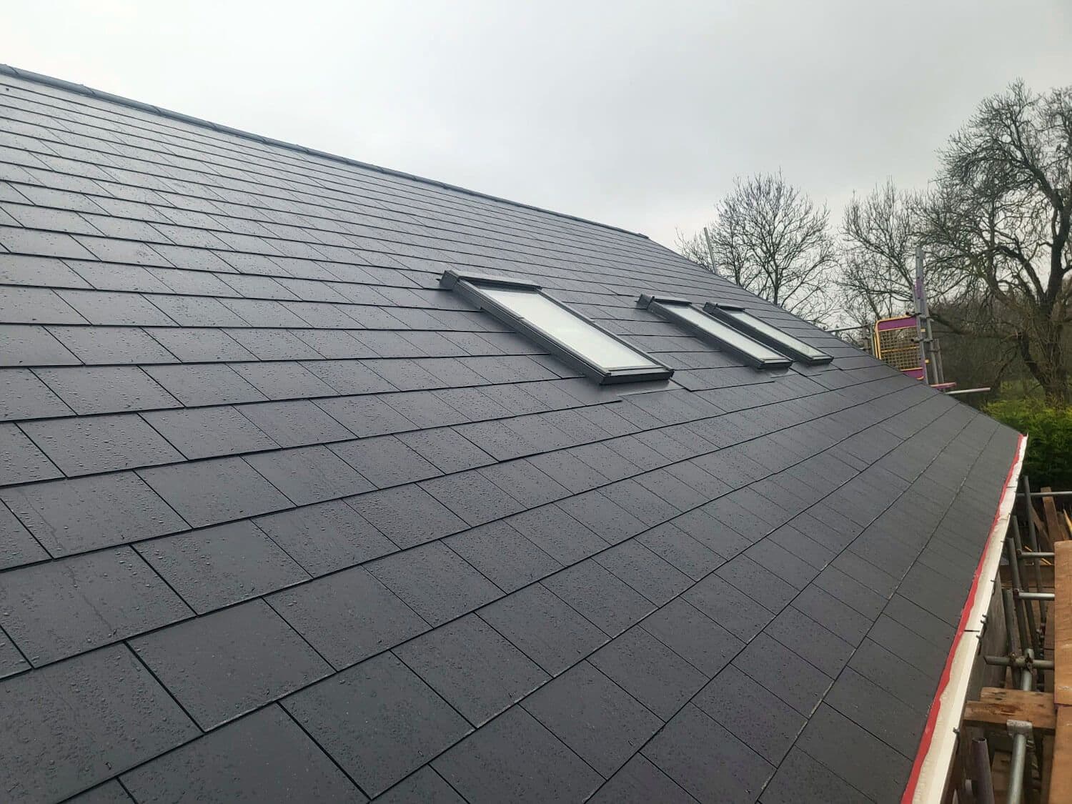 The finished grey tile roof with two Velux rooflights