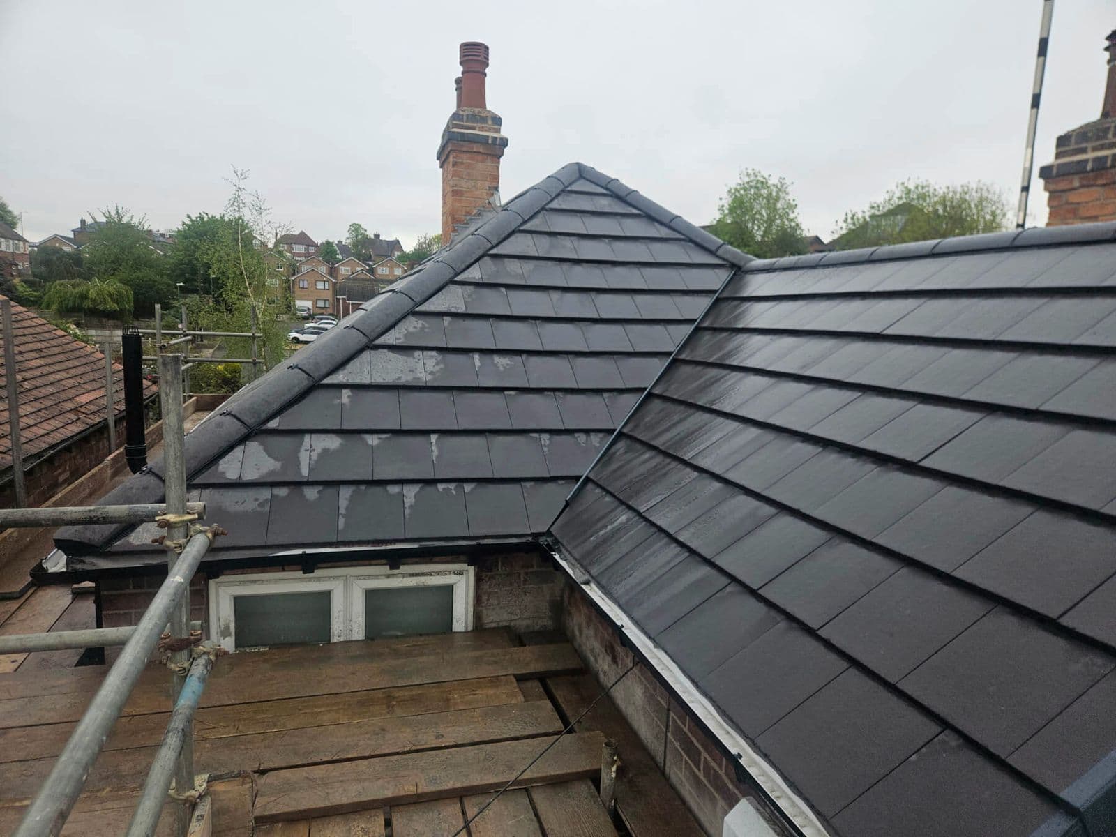 The finished grey tiled roof with the chimney repointed