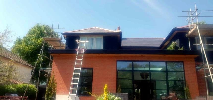 A ladder up to the gutter line of a house