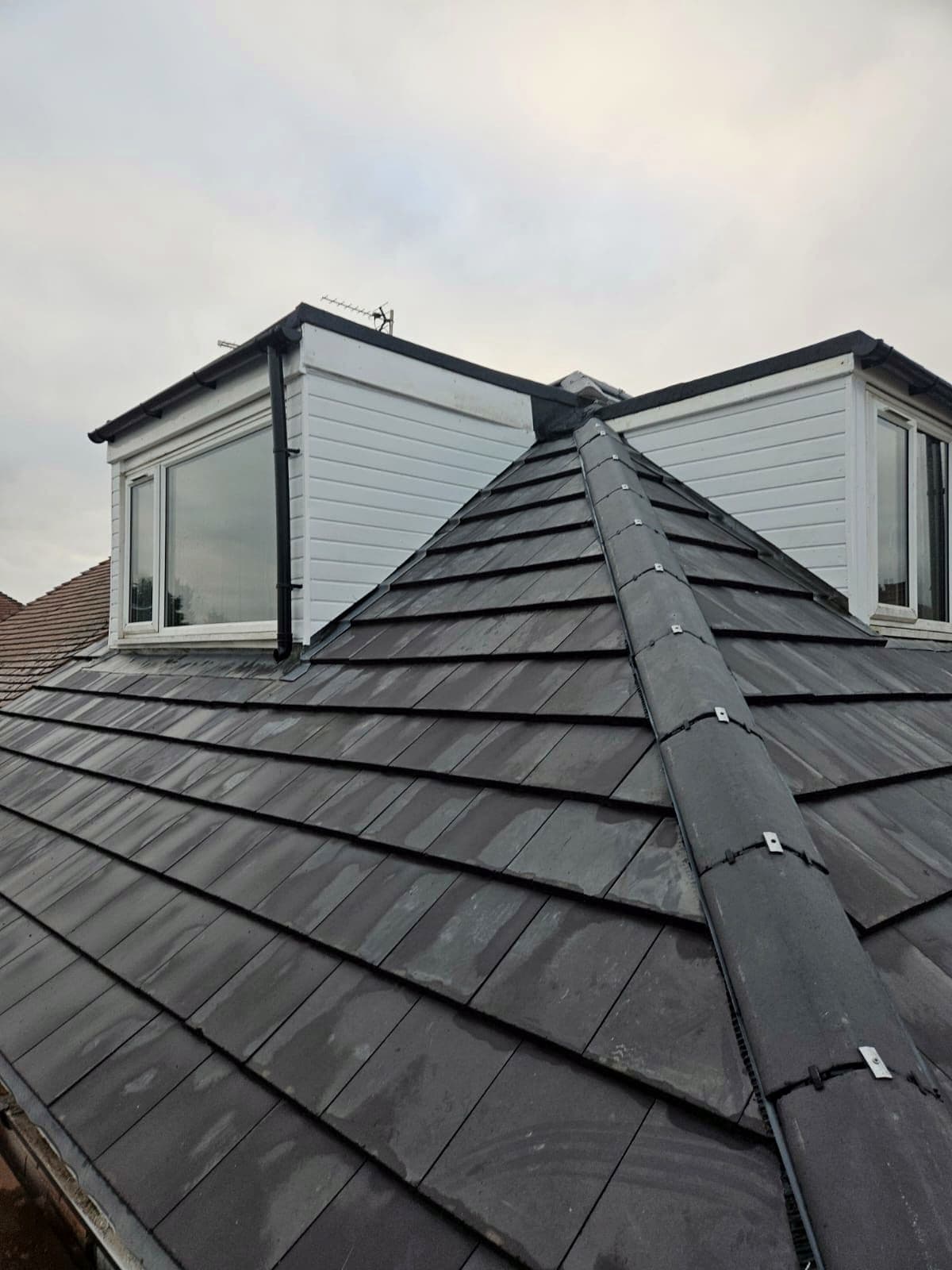 A finished slate roof with a dormer window