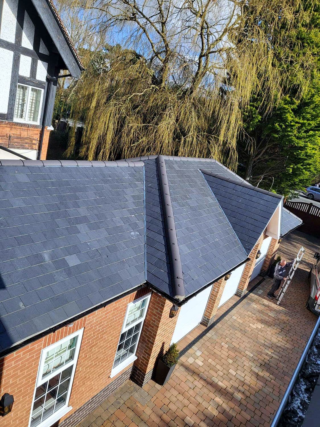 The slate garage roof from the side, with the house behind
