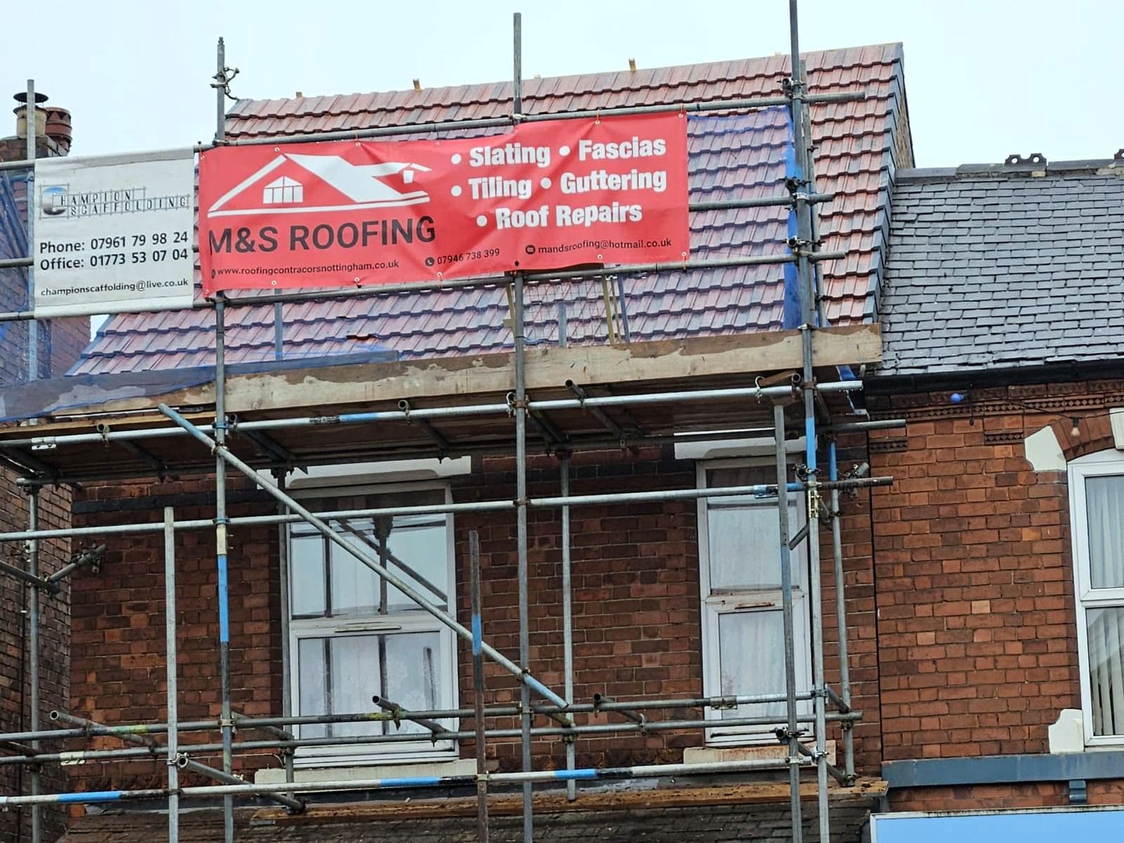The scaffolded terrace with the M&S Roofing banner up