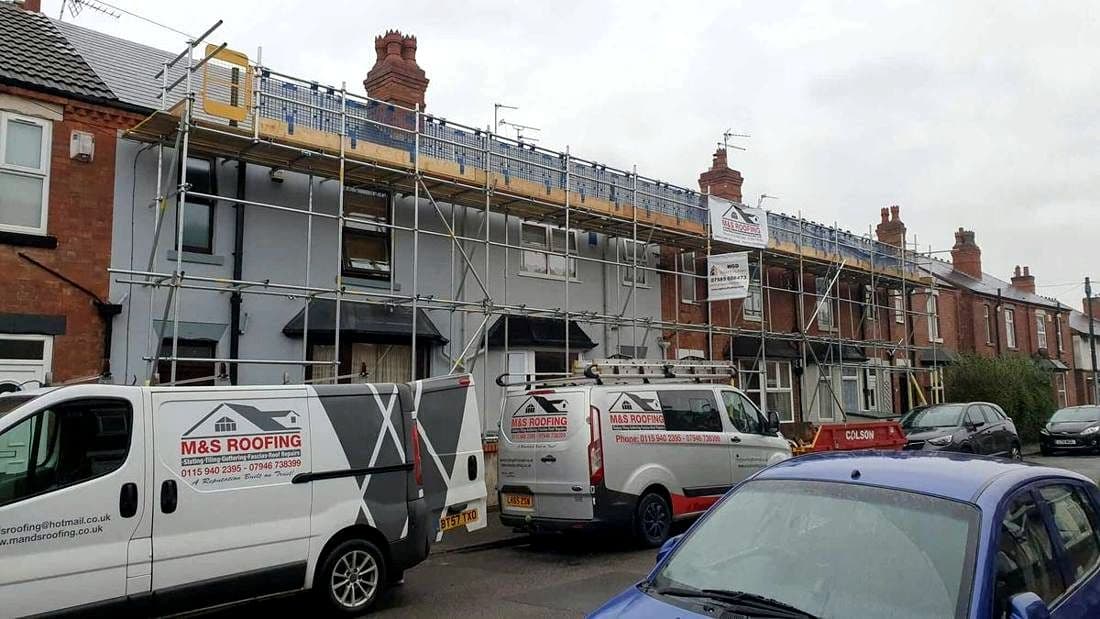 Three M&S Roofing vans parked outside a scaffolded terrace in Nottingham